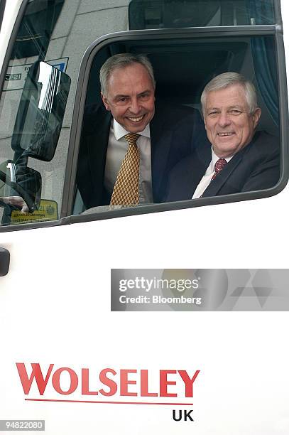 Charlie Banks, Wolseley chief executive, right, and finance chief Steve Webster pose against a Wolseley truck in London, Monday, March 21, 2005....