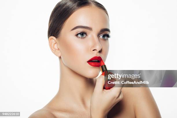 彼女の唇に赤い口紅を適用する女の子 - 赤の口紅 ストックフォトと画像
