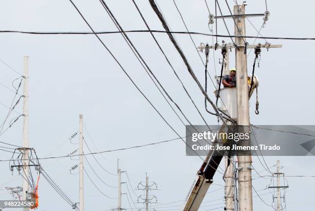 An employee of the Puerto Rico Electric Power Authority repairs a power lines affected by Hurricane Maria April 18, 2018 in San Juan, Puerto Rico. A...