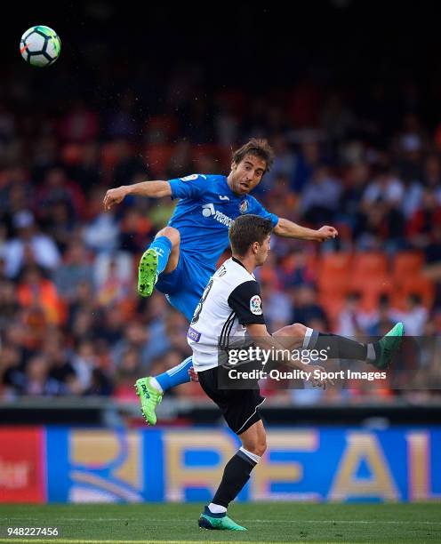 Luciano Vietto of Valencia competes for the ball with Mathieu Flamini of Getafe during the La Liga match between Valencia and Getafe at Mestalla...