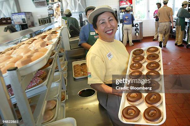 Salesperson Chantrapa Praseutsak shows off Krispy Kreme Doughnuts at the counter of a Krispy Kreme Doughnut shop in Alexandria, Virginia, May 25,...