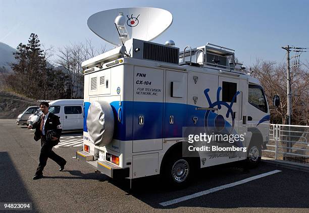Man walks past a Fuji Television truck in the parking lot of Central Japan Railway Co.'s Yamanashi Maglev Test Line in Yamanashi Prefecture, Japan...