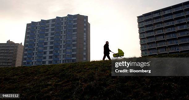 Man pushing a baby carriage passes apartment buildings on the dike in Terneuzen, The Netherlands, Tuesday, January 10, 2006.