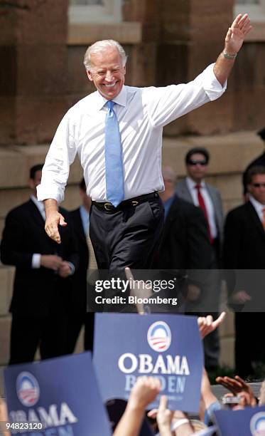 Joe Biden, a Democratic senator from Delaware, waves to supporters as he is introduced by Barack Obama, U.S. Senator from Illinois and Democratic...