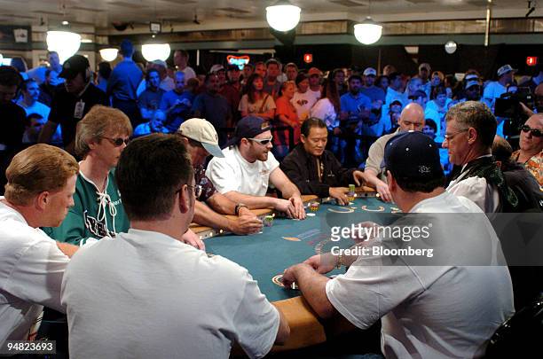 Part of a capacity crowd of spectators watches from behind the rail as gamblers, including 2003 winner Chris Moneymaker and Men "The Master" Nguyen...