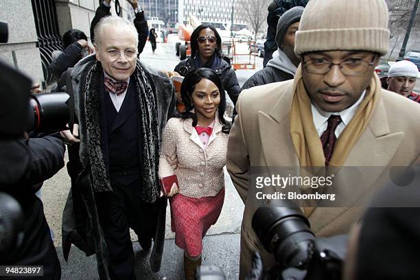 Kimberly Jones, better known as Rap star Lil' Kim, center, arrives at Manhattan Federal Court accompanied by her lawyer Mel Sachs, left, Friday,...
