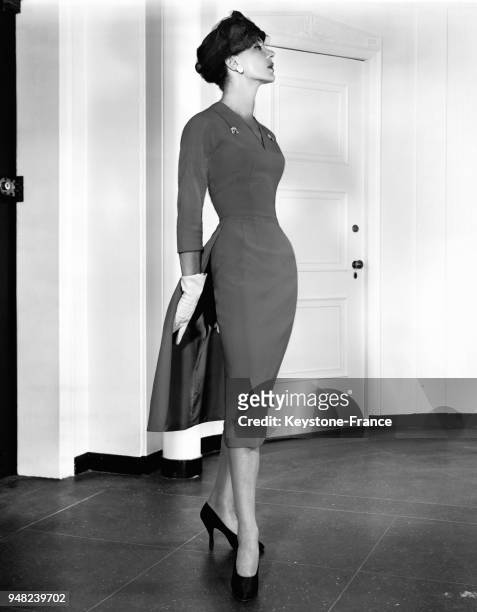 Mannequin présentant un modèle Paul Parnes créé par Beni Claire pour la Collection Automne 1956: une robe d'après-midi en crèpe et taffetas bleu roi...