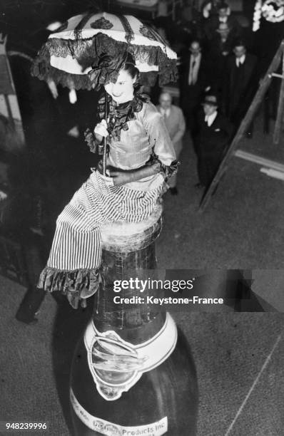 Une femme assise sur une bouteille de champagne géante fête la fin de la prohibition, à New York City, Etats-Unis en 1933.