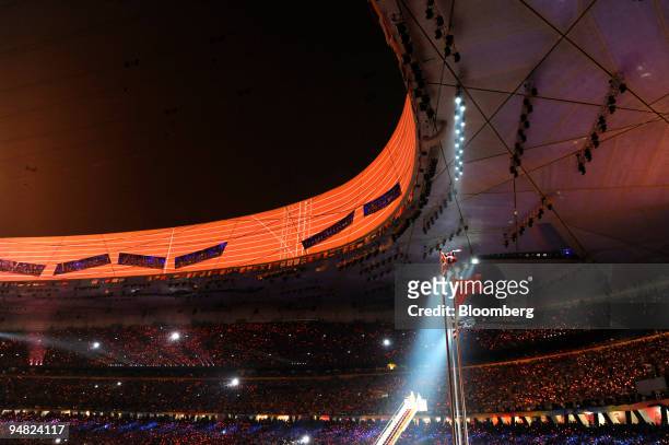 The British flag, Chinese flag, Olympic flag and Greek flag fly inside the National Stadium, also called the Bird's Nest, during the closing ceremony...