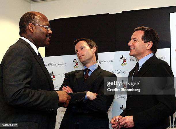 From left, Walt Disney Co. Director Alwyn Lewis, Chief Financial Officer Thomas Scaggs and President and Chief Operating Officer Robert Iger chat...