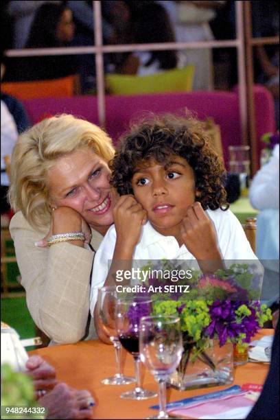 While sitting in the lap of a friend Jela Druppel, Boris Becker son Noah observes dad tv interview during a pre us open women's final party.