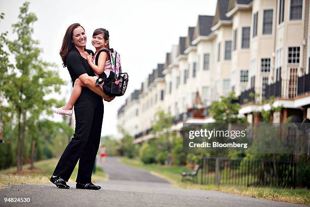 Ingrid Sanden, president of the Cameron Station Civic Association, holds daughter Maddy Miller as they pose for a portrait near their home in the...