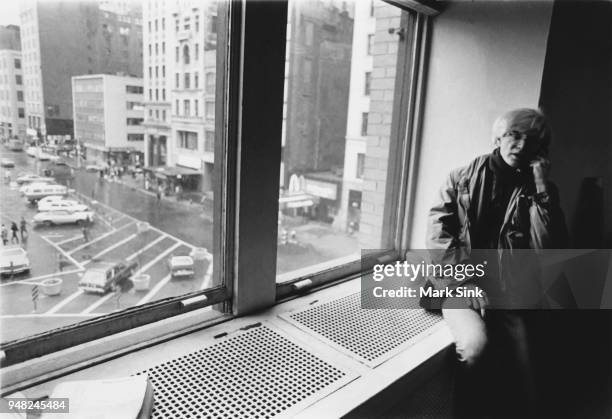 Artist Andy Warhol takes a phone call on the windowsill of the Factory at 860 Broadway on March 4 New York City, New York.