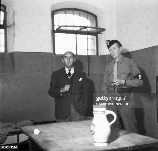 Fernand DE BRINON, a former minister of the Vichy government, in his cell with a member of the French military police the day after his arrest in...