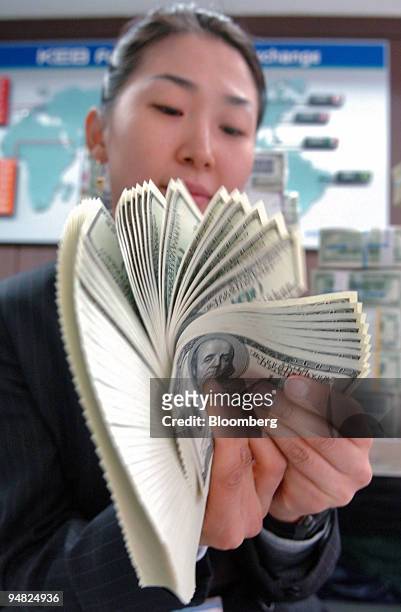 Korea Exchange Bank clerk checks U.S. Hundred dollar bills at the bank's headquarters in Seoul, South Korea Friday, January 6, 2006. Hana Financial...