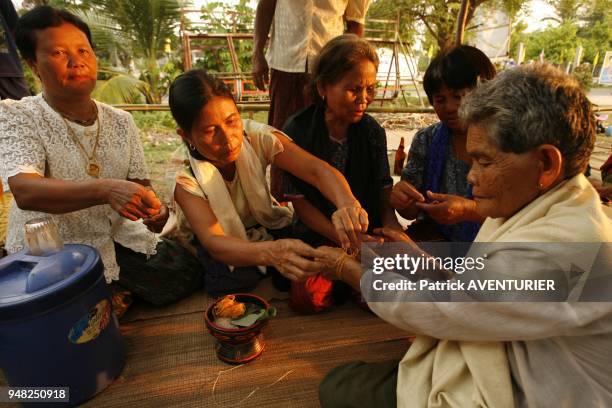 Little cotton bracelets coming from a Buddhist temple are put on the wrists to protect the participants at the ceremony.