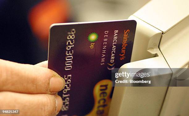 Shop worker credits loyalty points to a customers card at the Sainsbury supermarket in Cromwell Road, London, Wednesday, April 7, 2004.