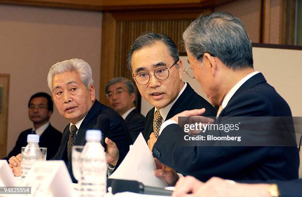 Nippon Broadcasting President Akinobu Kamebuchi, center, and Fuji Television Chairman / CEO Hisashi Hieda, right, discuss who should answer a...