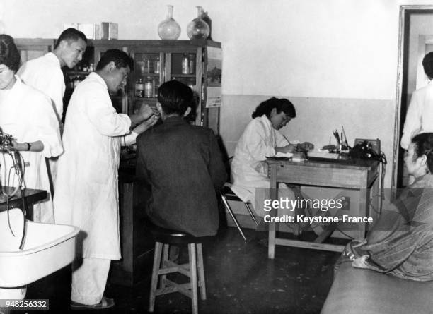 Ans après le bombardement atomique, à l'hôpital d'Hiroshima un médecin ausculte un jeune homme afin de prévenir des effets de la bombe, à Hiroshima,...