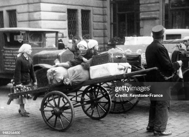 Porteurs de gros sacs de linge et de literie, les réfugiés du territoire des Sudètes affluent à Prague, Tchécoslovaquie en octobre 1938.