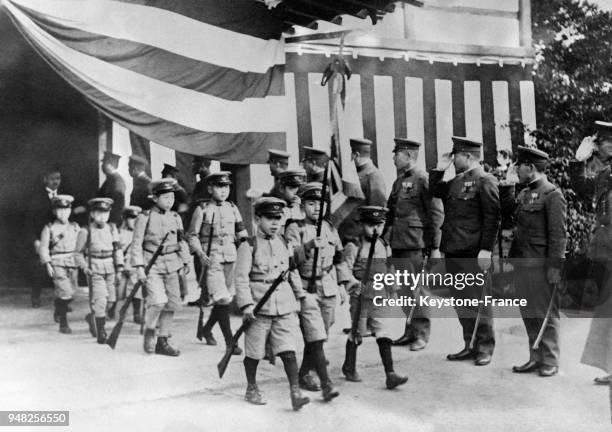 De jeunes garçons japonais âgés de moins de 8 ans, portant l'uniforme militaire, sortent d'un temple après un offices célébré à la mémoire des...