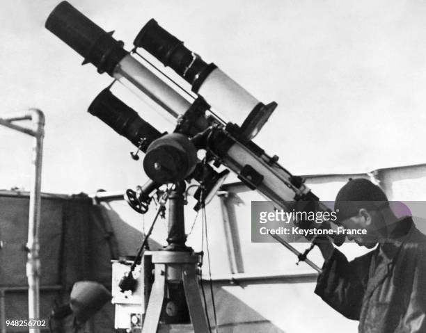 Shimichi Shimizy, un astronome amateur qui a trouvé une nouvelle planète, est photographié règlant sa lunette astronomique, à Tokyo, Japon en 1939.