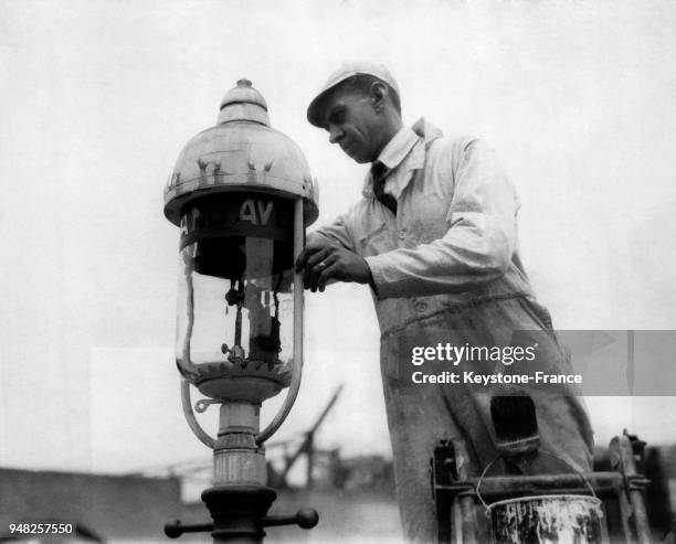 Peintre peignant un faux réverbère , servant pour un décor de cinéma à Hollywood, Los Angeles, aux Etats-Unis, en mars 1925.