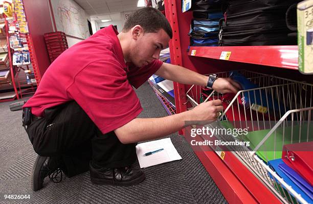 Sales associate Hector Acevedo takes inventory of binders in a Staples store in New York on May 18, 2004. Staples Inc. And Home Depot Inc. Reported...