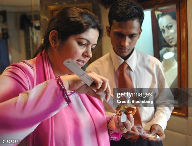 Manager measures a jewel before approving for a sale under the eye of an assistant in a Tanishq jewelry store in Mumbai, India, on December 26, 2005....