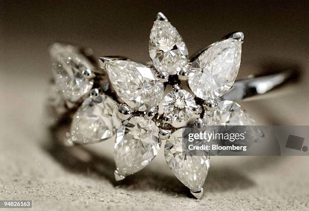 This De Beers? "Cocktail Fizz Ring" consists of one round diamond along with several pear shaped diamonds and is sold for $11 in Los Angeles,...