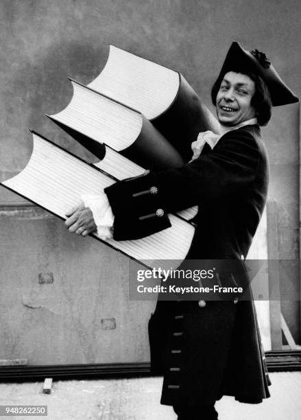 Un homme déguisé en personnage de Gulliver transporte de gros volumes représentant des livres en vue de la parade du Lord Mayor's Show, circa 1950 à...