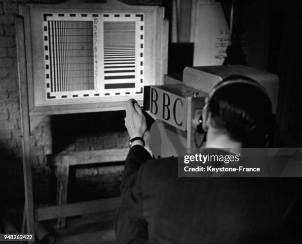 Caméraman testant l'image de sa caméra avec le line test dans les studios de télévision de la BBC, à Londres, Royaume-Uni circa 1940.