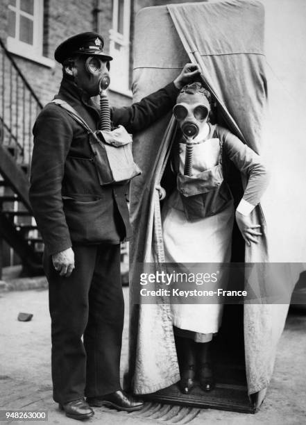 Une infirmière sort du fourgon anti-gaz du ministère de l'Intérieur avec un masque à gaz sur le visage, à Londres, Royaume-Uni le 4 mars 1938.