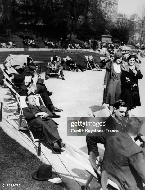 L'heure du déjeuner, les Londoniens profitent du soleil dans le jardin de Victoria Embankment à Londres, Royaume-Uni le 10 avril 1931.