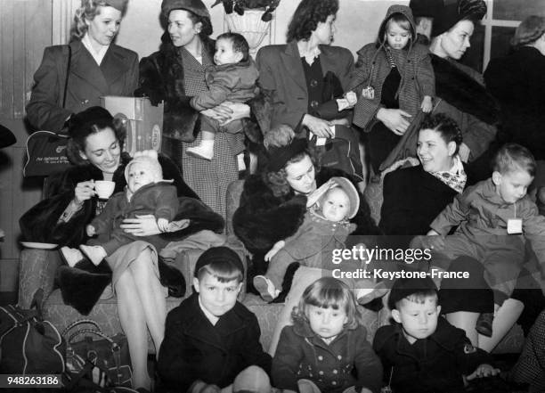 Des femmes de militaires américains et leurs jeunes enfants font escale à l'aéroport d'Heathrow avant de rejoindre leurs époux en service sur la base...