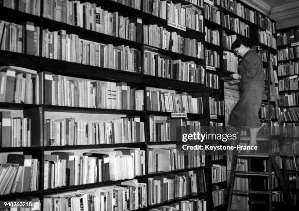 Bibliothécaire lisant un livre de la Bibliothèque Wiener à Londres, Royaume-Uni en mars 1957.