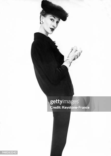 Mannequin présentant un modèle John Cavanagh de la Collection Printemps 1956: un costume en laine bleu navy, à Londres, Royaume-Uni, en février 1956.