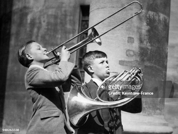 Deux jeunes garçons s'entraînent avant de jouer au Queen's Hall lors du festival de musique des écoles le 2 juin 1934 à Londres, Royaume-Uni.