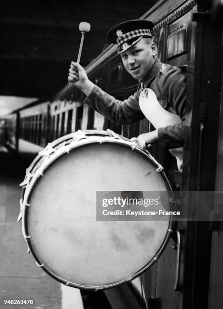 Un soldat de l'orchestre de la garde royale photographié avec sa grosse caisse à la porte du train au départ de la gare Victoria à Londres,...