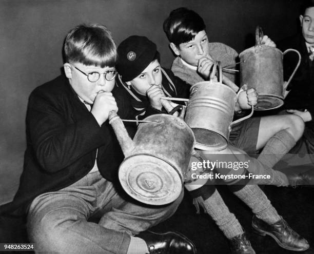 Garçons soufflant dans un arrosoir avant de passer l'audition, à Londres, Royaume-Uni en novembre 1958.