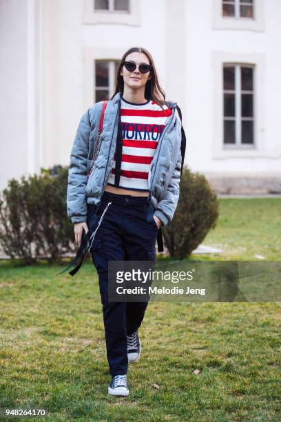 Italian model Vittoria Ceretti wears black sunglasses, gray bomber jacket after a Alberta Ferretti "Tomorrow" red and white striped top, black cargo...