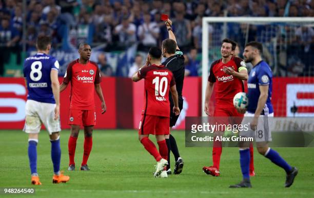 Referee Robert Hartmann shows the red card to Gelson Fernandes of Frankfurt during the Bundesliga match between FC Schalke 04 and Eintracht Frankfurt...