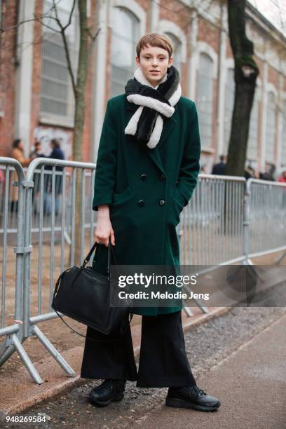 Model Gisele Fox wears multi-color white, black and green fur scarf, a green coat, black Coach bag, and black sneakers and pants after the Fendi show...