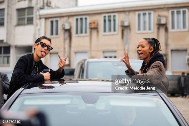 Models Dilone and Adesuwa Aighewi exit the Roberto Cavalli show and throw middle fingers and peace signs out of their car during Milan Fashion Week...