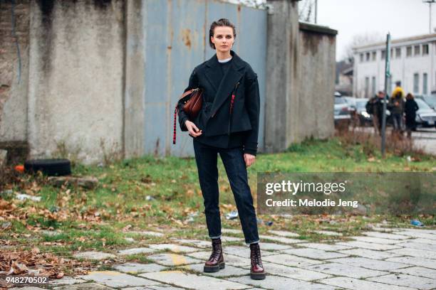 Model Vasilisa Pavlova wears a Proenza Schouler jacket, a J.W. Anderson bag, cropped jeans, and red Doc Marten boots during Milan Fashion Week...