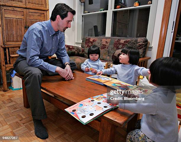 David Youtz, President of Families with Children from China, reads to his daughters Anna, left, Alice, middle, and Nora at their home in Tenafly, New...