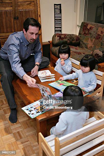 David Youtz, President of Families with Children from China, reads to his daughters Anna, top, Alice, middle, and Nora at their home in Tenafly, New...