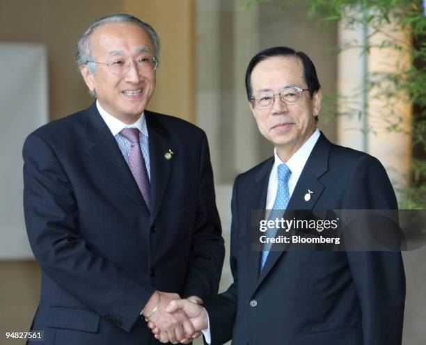 Nobuo Tanaka, executive director of the International Energy Agency , left, shakes hands with Yasuo Fukuda, Japan's prime minister, as he arrives for...
