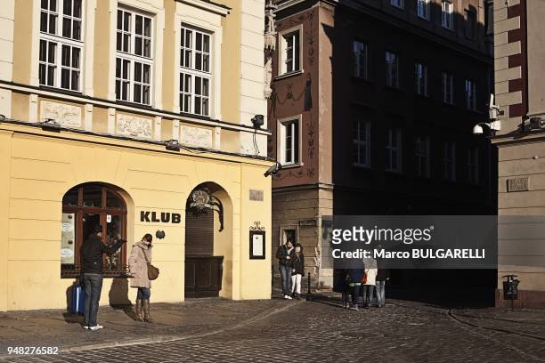 Young people in the Old Market Square or Stary Rynek in Poznan in Poland, on November 12, 2011. The central square of the city established in 1253 on...