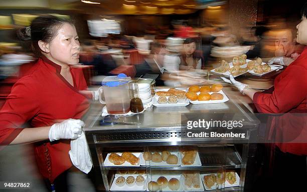 Servers push carts containing dim sum dishes at Zilver, a restaurant in the Chinatown district of Sydney, Australia, on Sunday, Aug. 10, 2008. If...